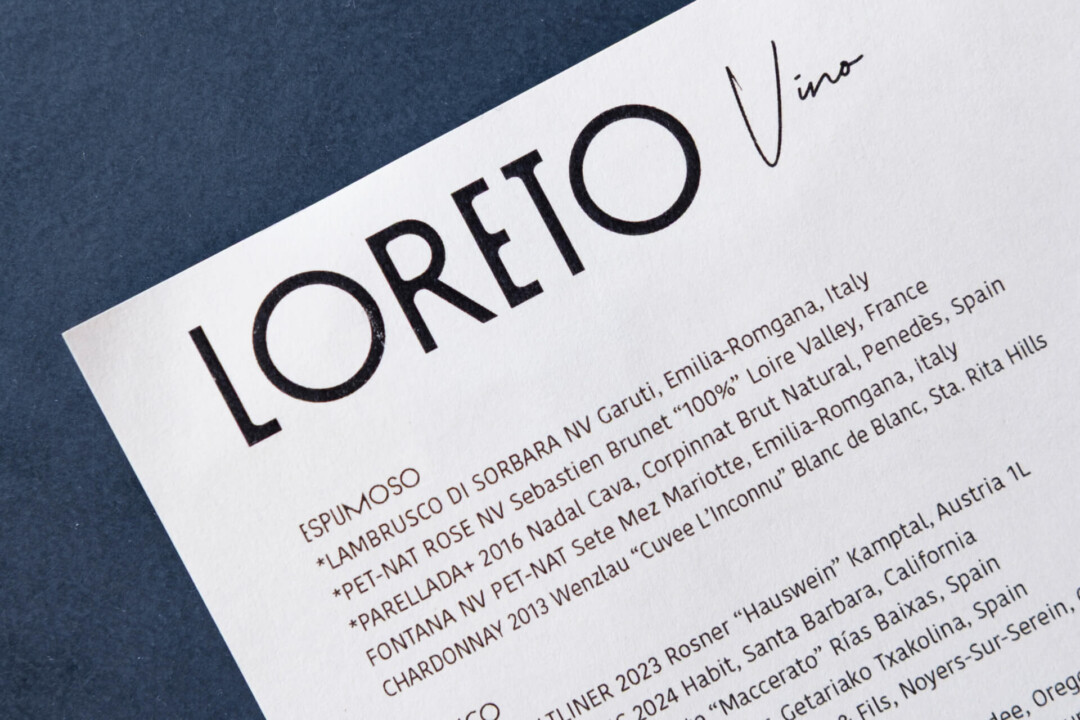Wine menu from Loreto Vino featuring Italian and French wines, sparkling and white varieties, stylish black typography.