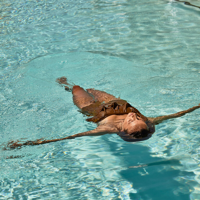 Woman floating and relaxing in a pool.