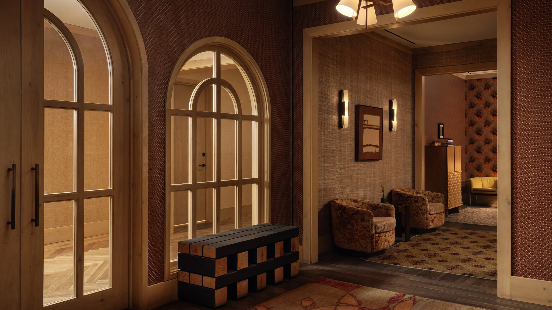 Inside Verbena Spa, arched cream-framed windows and a doorway into a rattan-walled sitting room with two swivel armchairs, all of it lit low and warm.