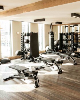 Modern fitness studio with weight benches, treadmills, dumbbells, and strength training equipment