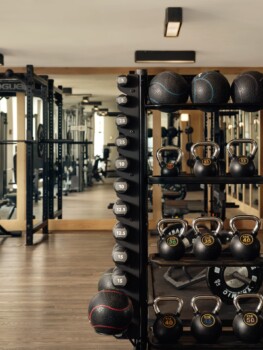 Kettlebells, dumbbells, and medicine balls neatly arranged in a gym