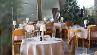 Indoor restaurant dining area with tables, chairs, and table settings