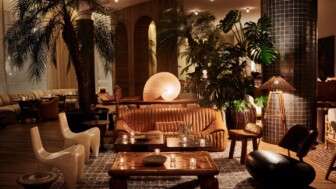 Indoor lounge with seating, wooden coffee table, large plants, and soft ambient lighting