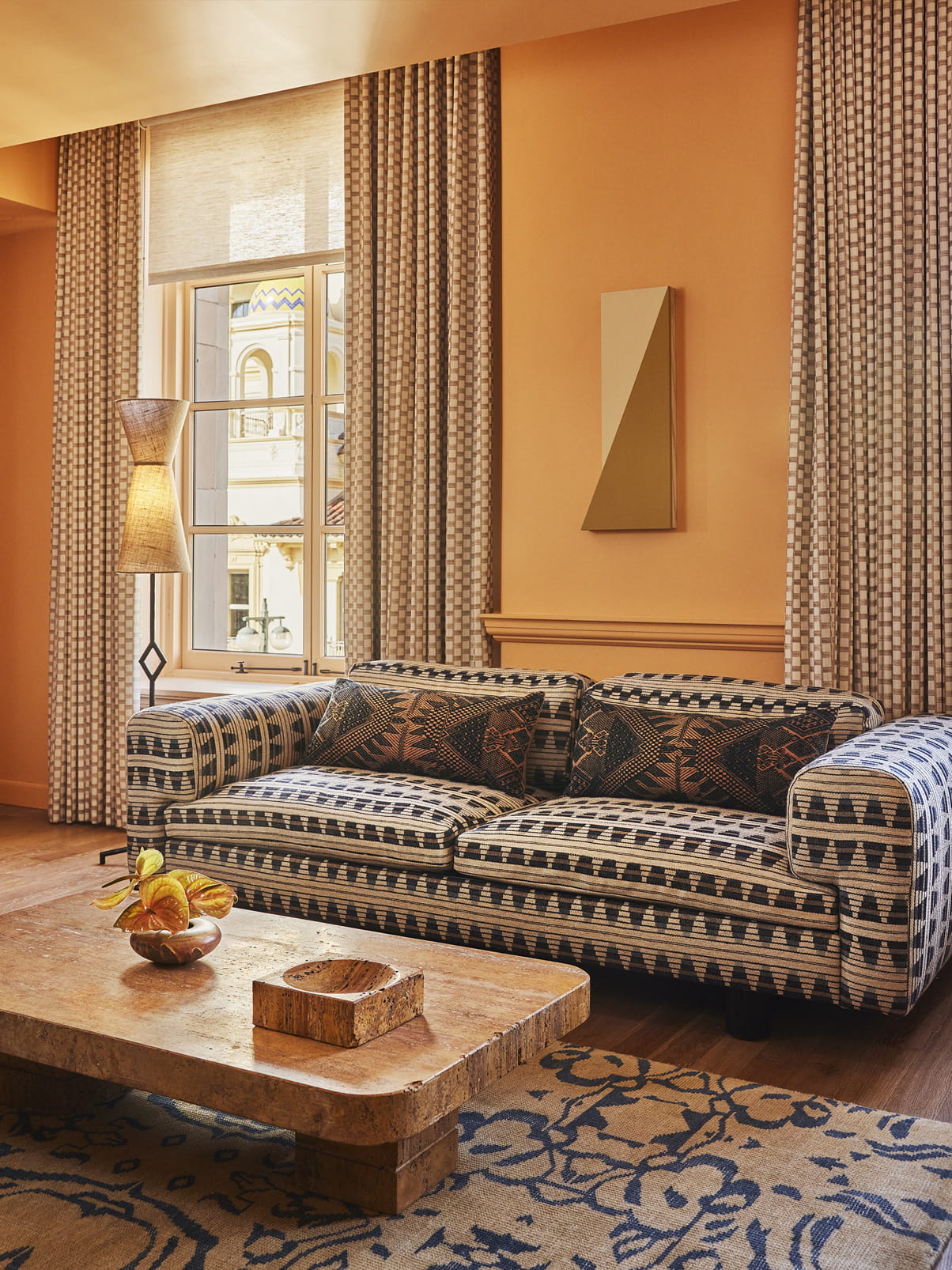 Stylish living room with patterned sofa, wooden coffee table, and warm decor