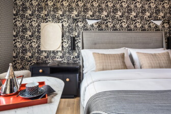 Boutique hotel bedroom with floral wallpaper and modern king bed setup